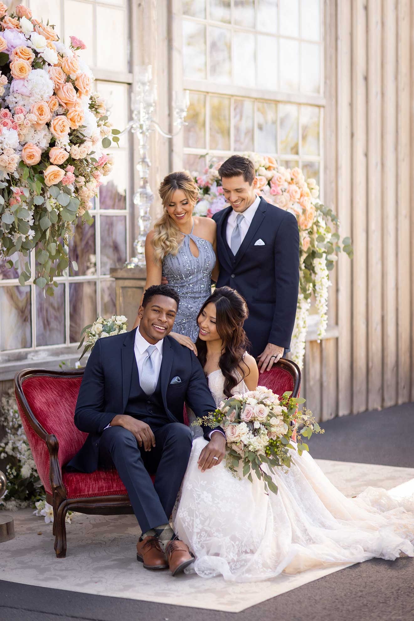 A groom posing for a photo in front of flowers while wearing a Michael Kors Navy Sterling.