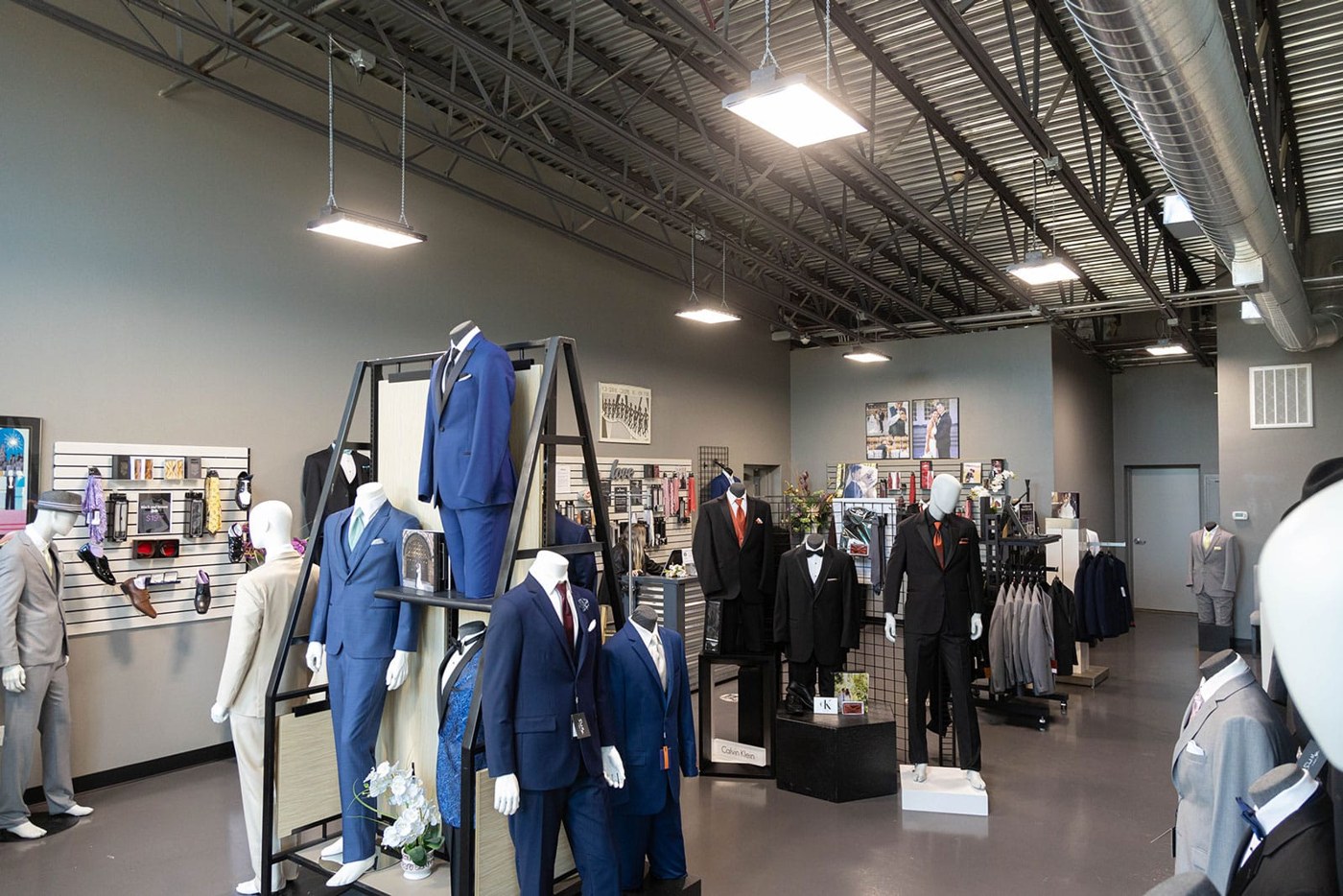 A men's clothing store offering tuxedo and suit rentals with mannequins showcasing the latest styles.